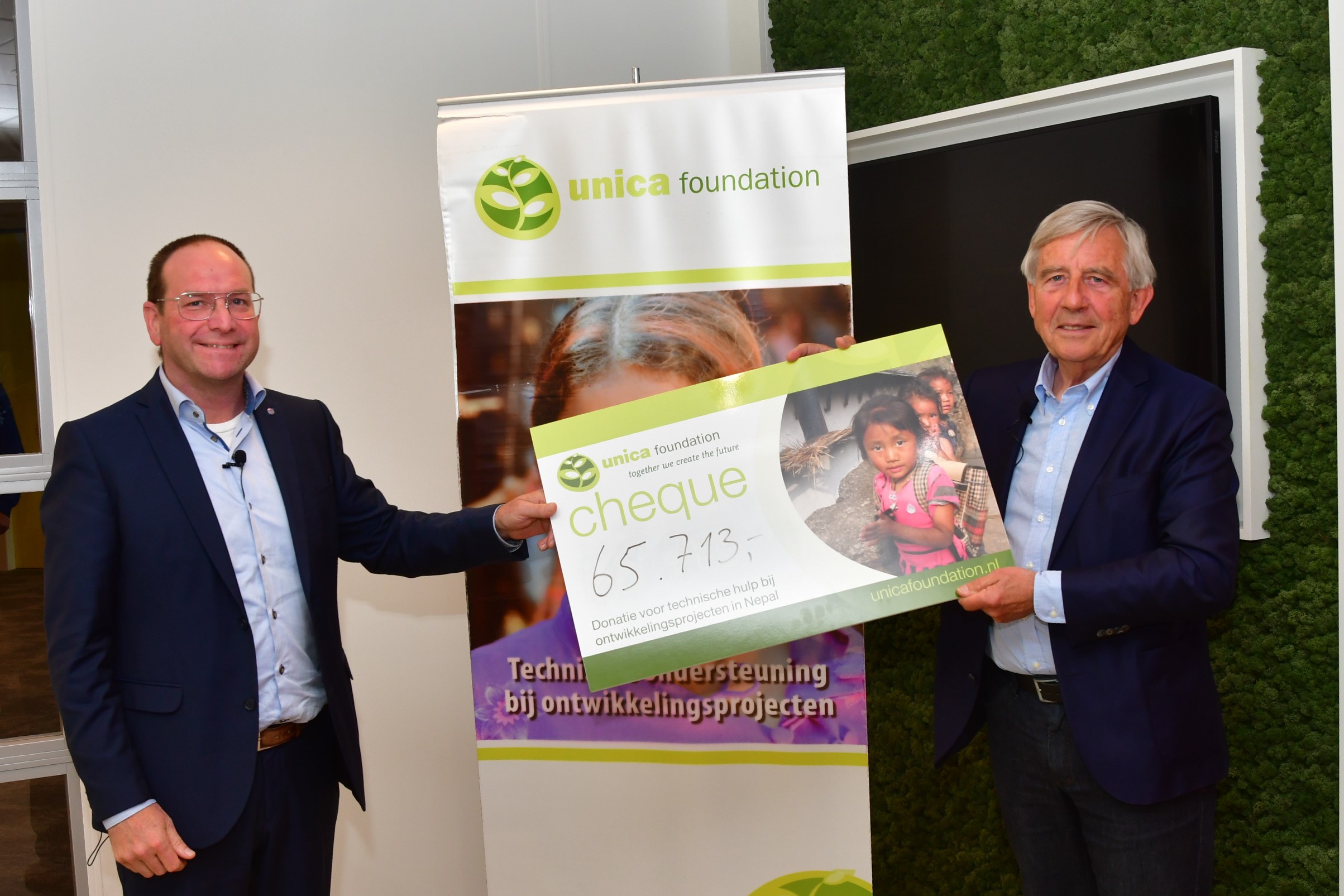 Ed Staal (directeur marketing & commercie, Unica) overhandigt cheque met opbrengst aan Daan van Vliet (voorzitter, Unica Foundation)